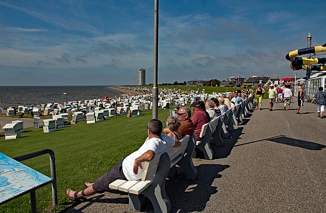 Büsum - Dike with beach chairs near the city center; in the background, the Büsumer high-rise pierces the sky